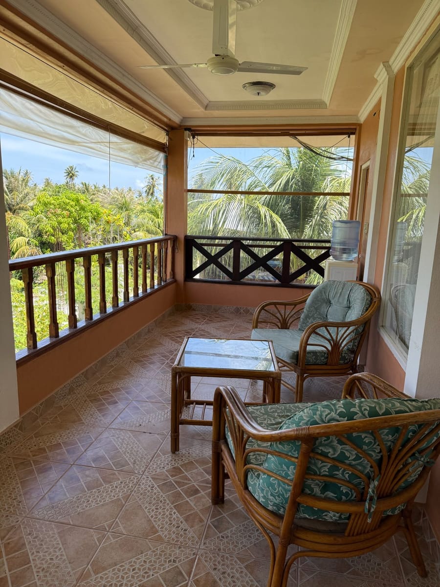 The shared veranda on the first floor with rattan chairs