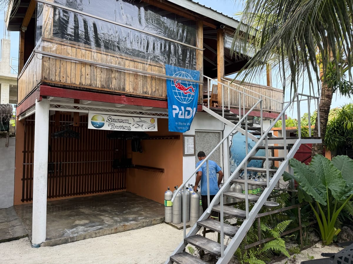 The dive centre under the house, with the PADI flag and the stairs up