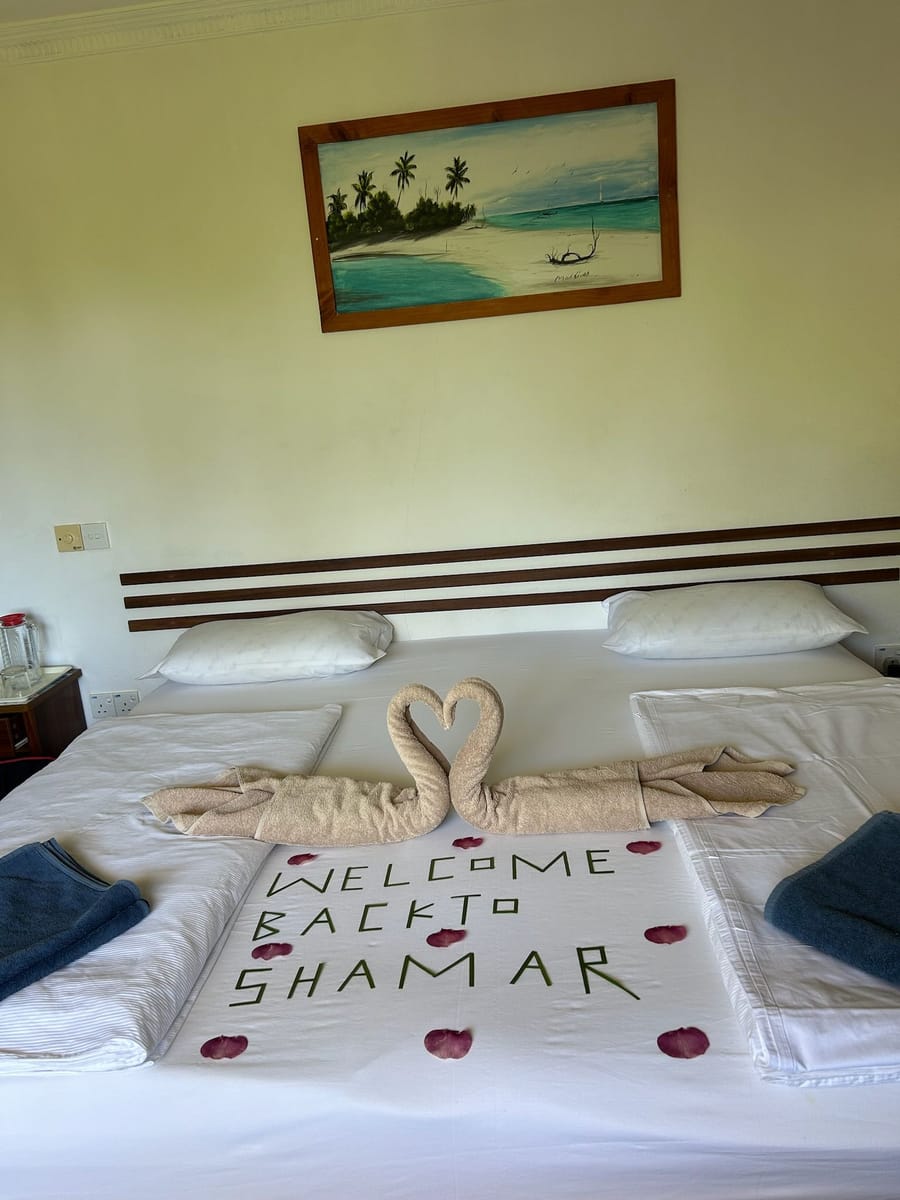 Towel swans and “Welcome back to Shamar” on a freshly made bed
